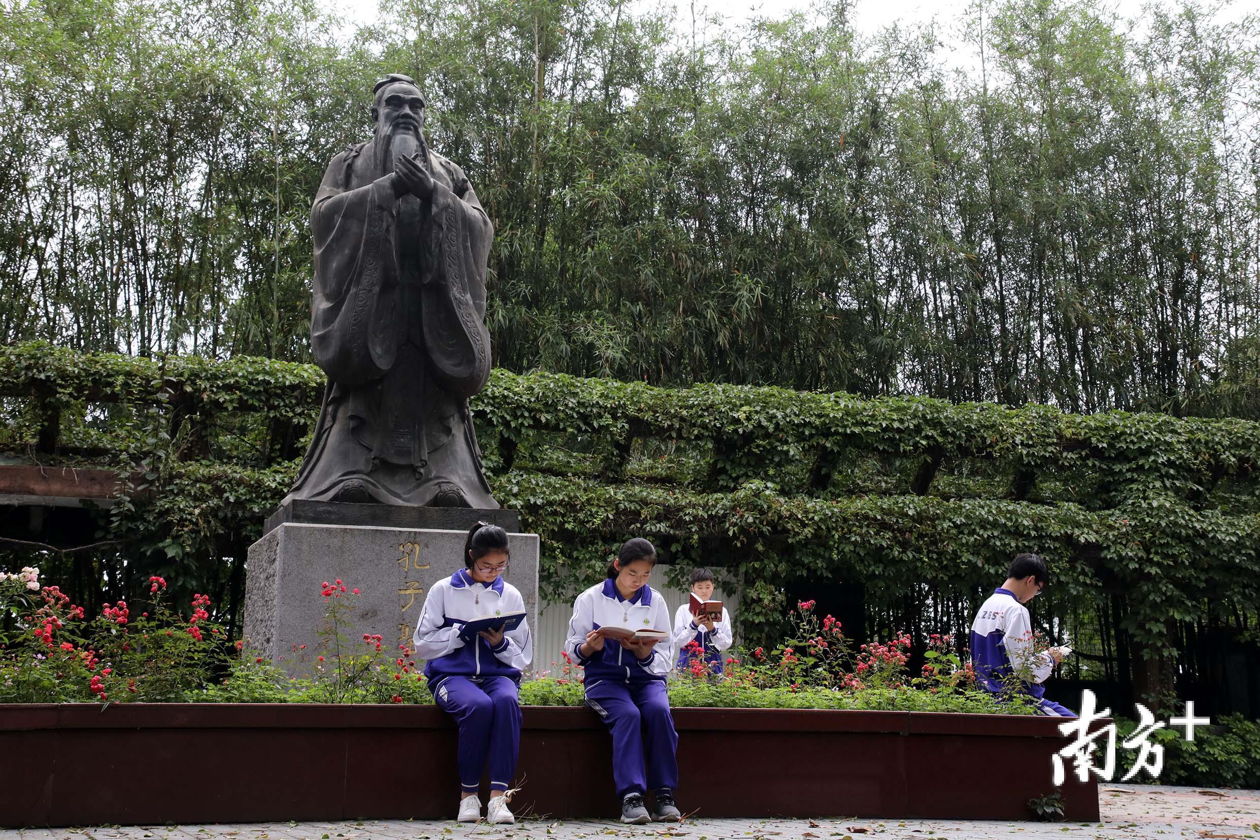 六十五中的学生们在孔子圣像周围阅读。