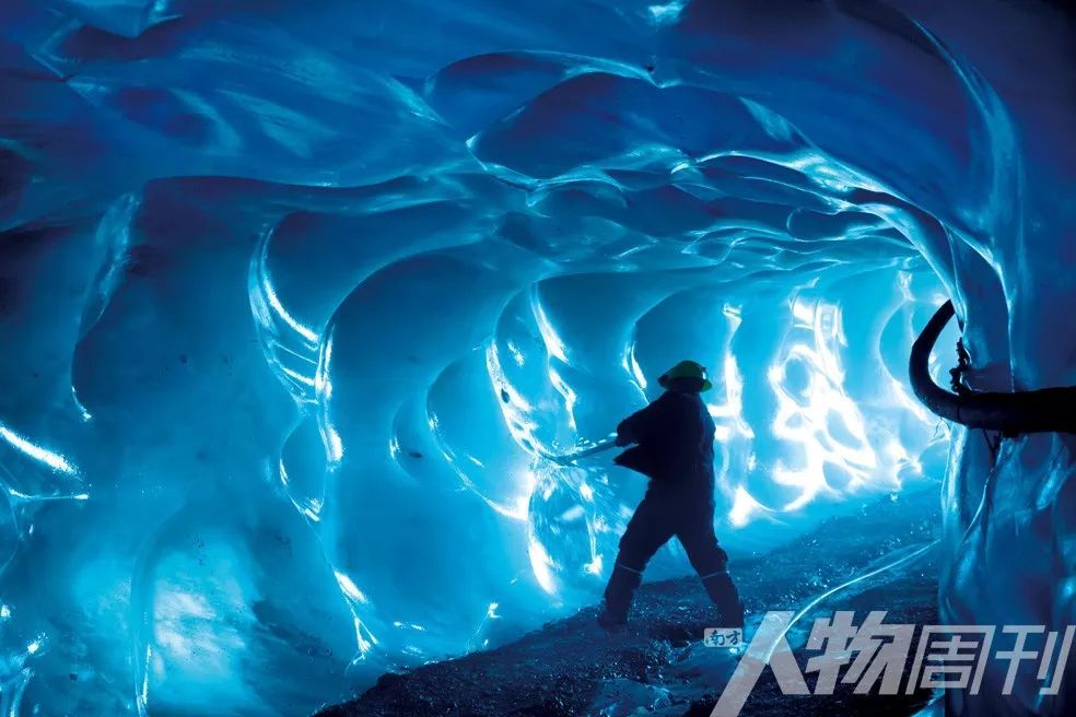 一名矿工在金矿的冰川隧道里凿冰。
