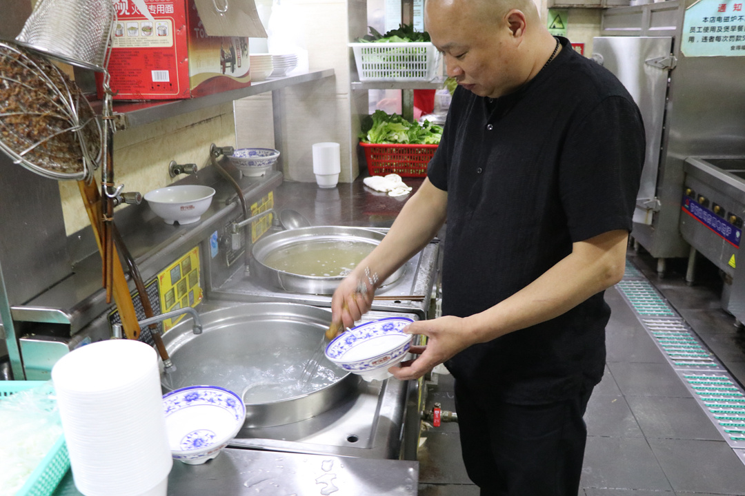 看似简单的烫粉有着不少讲究，全靠厨师常年的经验积累。     李彤晖摄