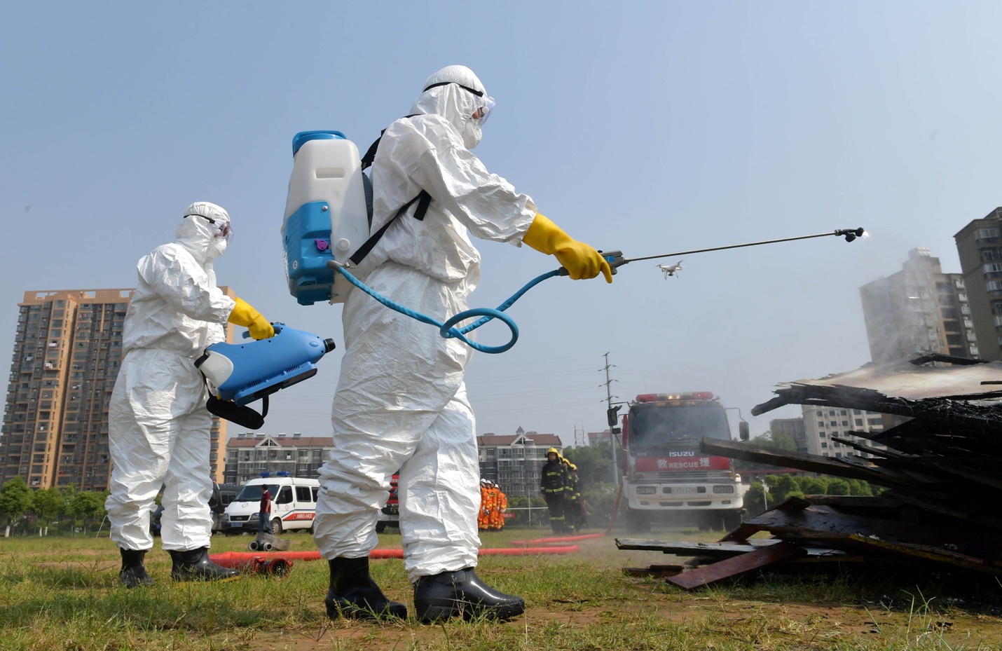 图为参加应急演练的工作人员在模拟灾后防疫.