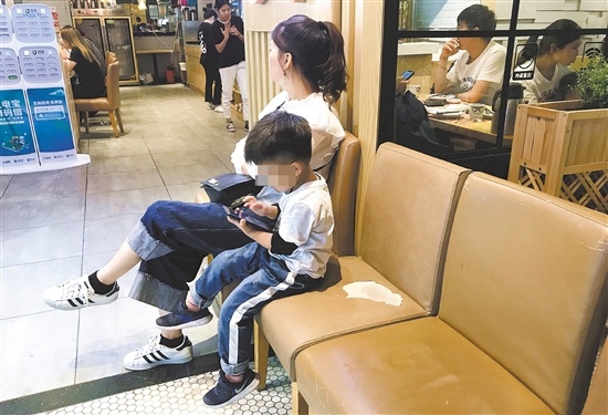 不少家长选择用手机换取孩子的安静。 