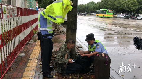 外地老人因人生地不熟迷路，被突如其来的大雨淋湿，民警脱下雨衣为其挡雨。高明公安供图