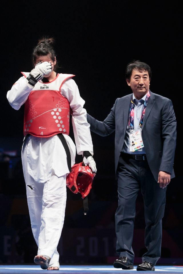 郑姝音（左）与中国队主教练管建民在比赛结束后。新华社发（乔恩·休珀摄）