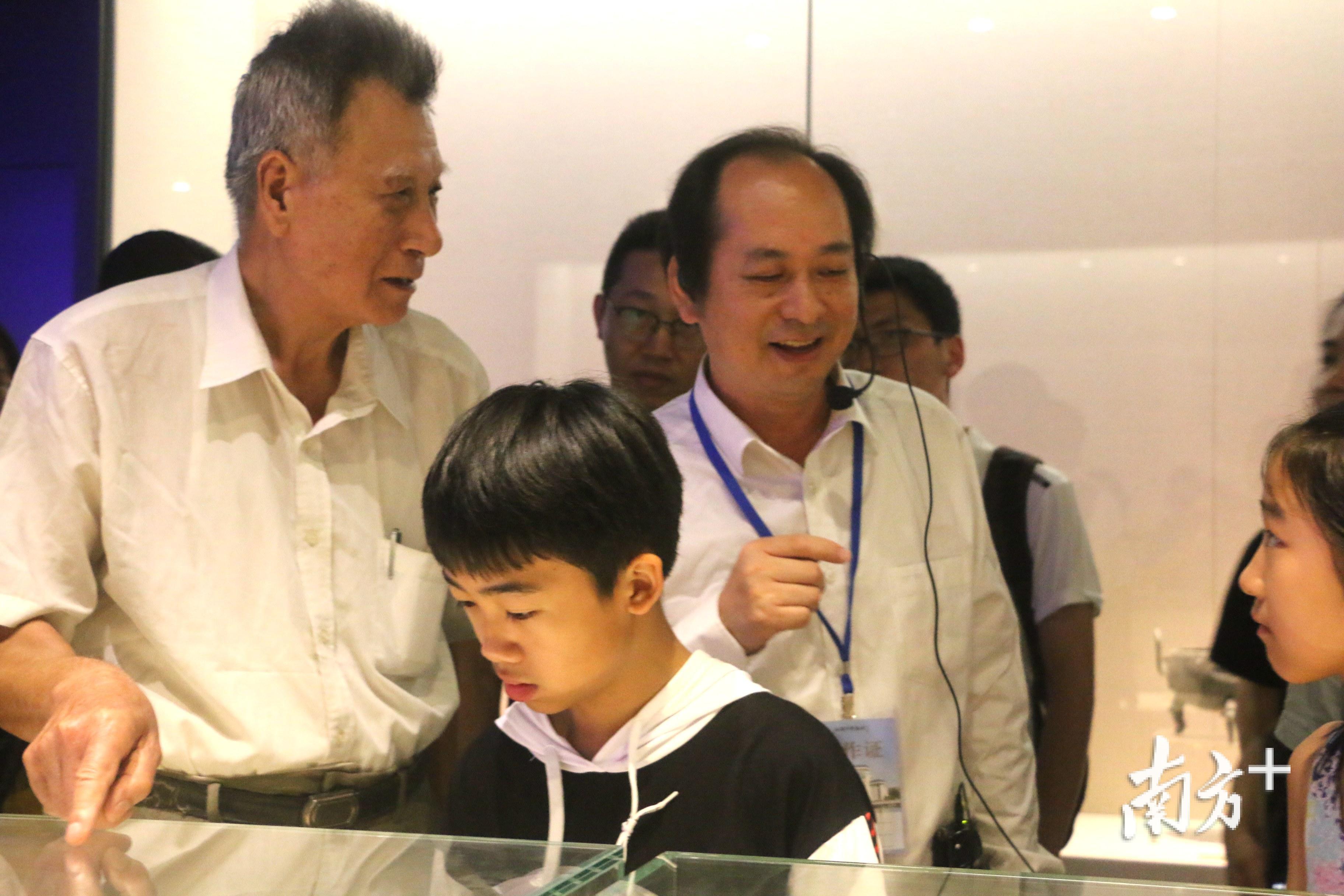 71岁的“老汕头”肖裕标（左一）与博物馆副馆长洪勇（中间着白衬衫者）探讨汉代文物“一刀平五千”刀币的历史背景。张伟炜 摄