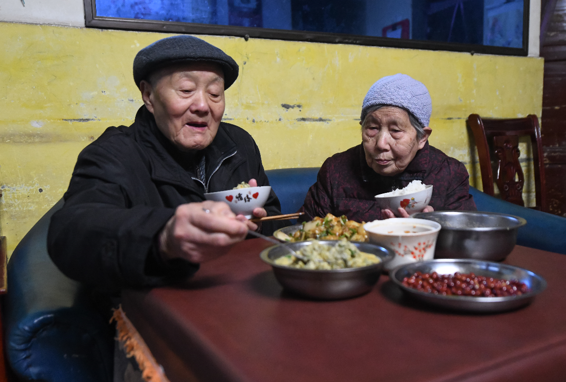 张富清和老伴在家里吃晚饭。