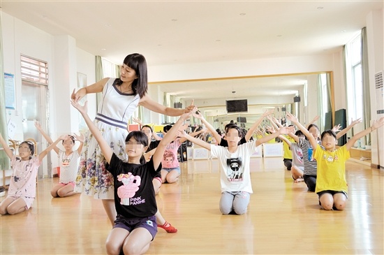 邓小燕在教孩子们跳舞。 