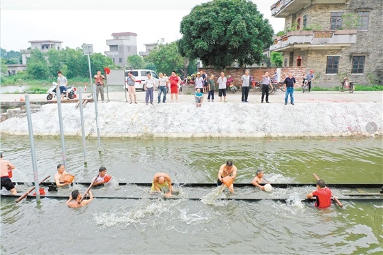 鹤山古劳镇仁和村举行“起龙”仪式，“扒丁”们潜入水中，托起水中的龙船。