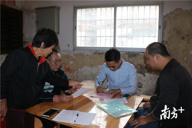 “90后”村干部洪炎明正与老一辈村民商讨村里的建设事宜。翁丹萍 摄