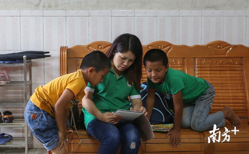 志愿者在用助学平板电脑教孩子学习英语。 志愿者在用助学平板电脑教孩子学习英语。