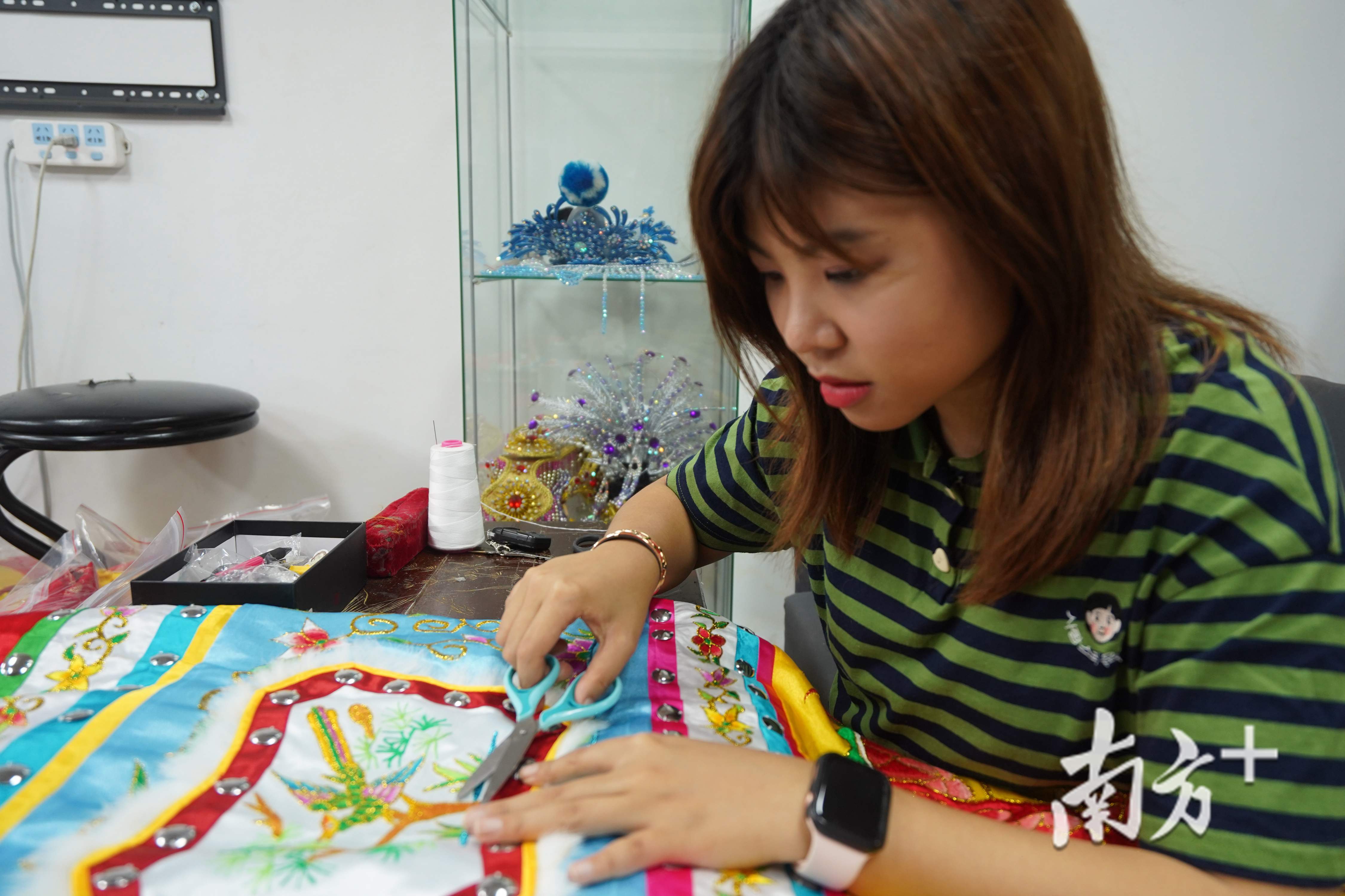 何凤婷剪去罗伞上的线头。