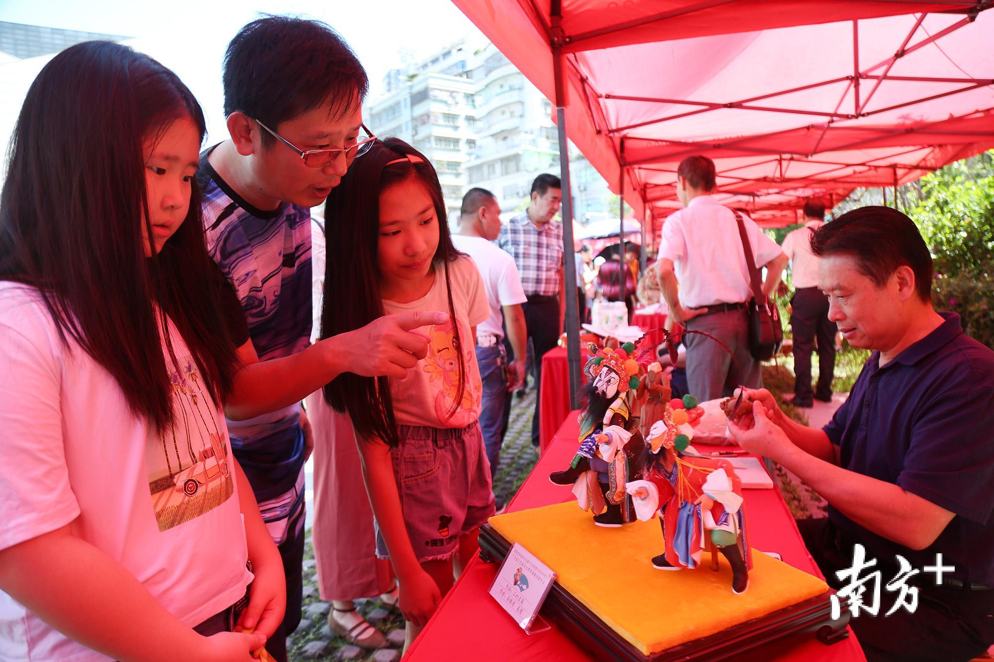 6月8日,潮州市文化馆门口,观众们在参观大吴泥塑项目非遗传承人吴维清的作品。 6月8日,潮州市文化馆门口,观众们在参观大吴泥塑项目非遗传承人吴维清的作品。