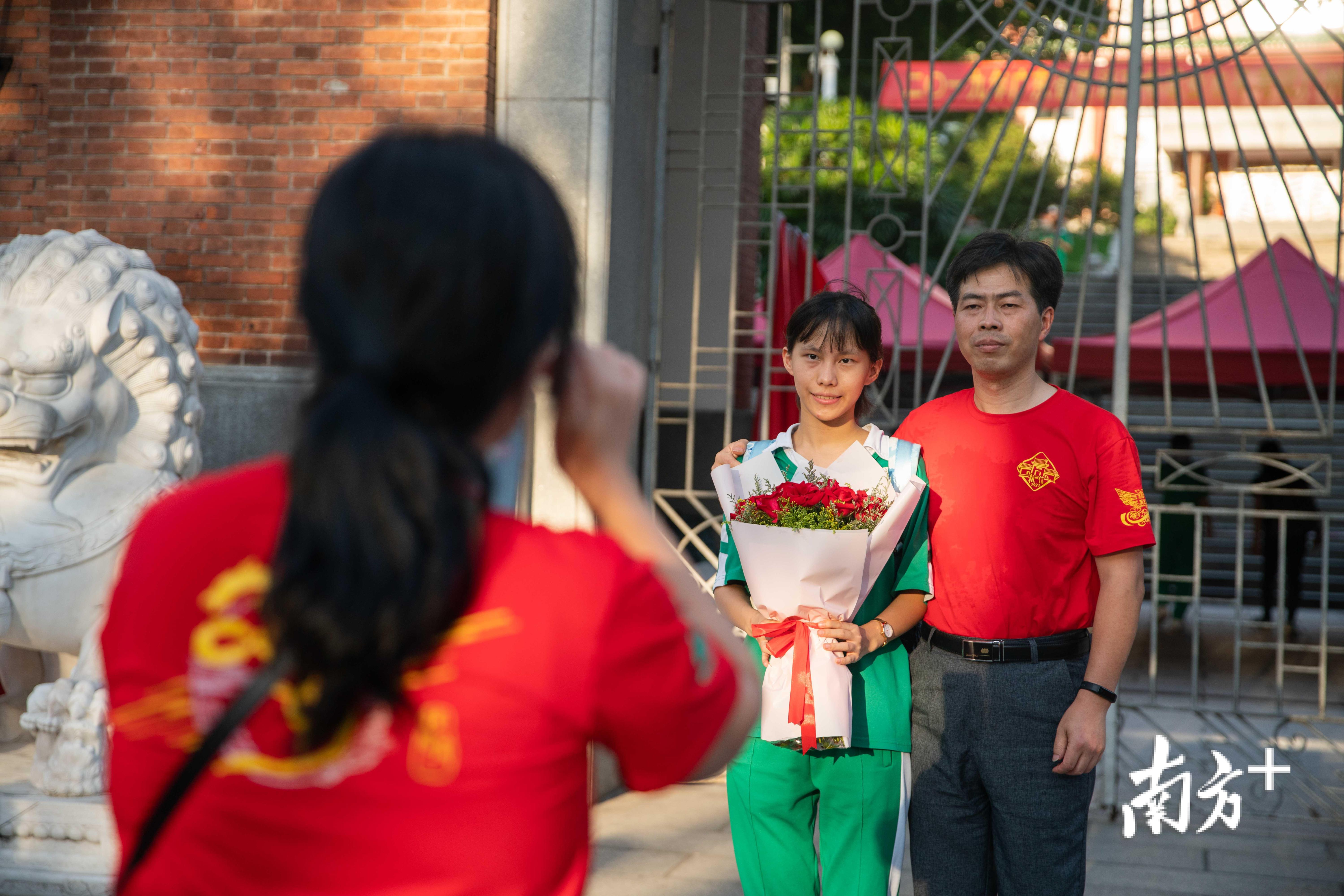 广州市执信中学,考生们在考后相拥庆祝,家长们也来到校园迎接子女.