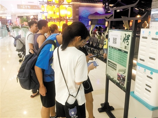 汇悦城内某店铺前,顾客扫码看菜单。 汇悦城内某店铺前,顾客扫码看菜单。