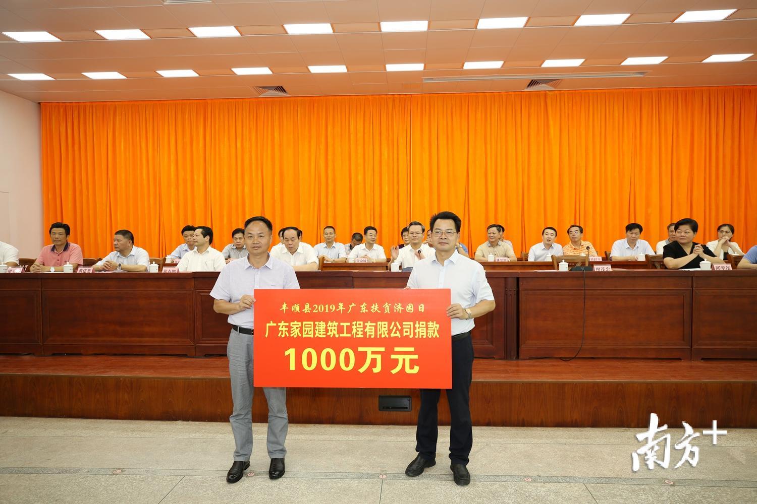 广东家园建筑工程有限公司举牌捐款1000万元，县长廖茂忠代表县政府接受捐款。（胡金辉 摄）