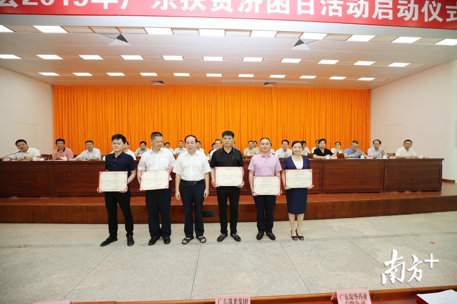 县人大常委会主任徐庆青为荣获2018年度丰顺县扶贫济困银奖的单位颁发证书。（胡金辉 摄）