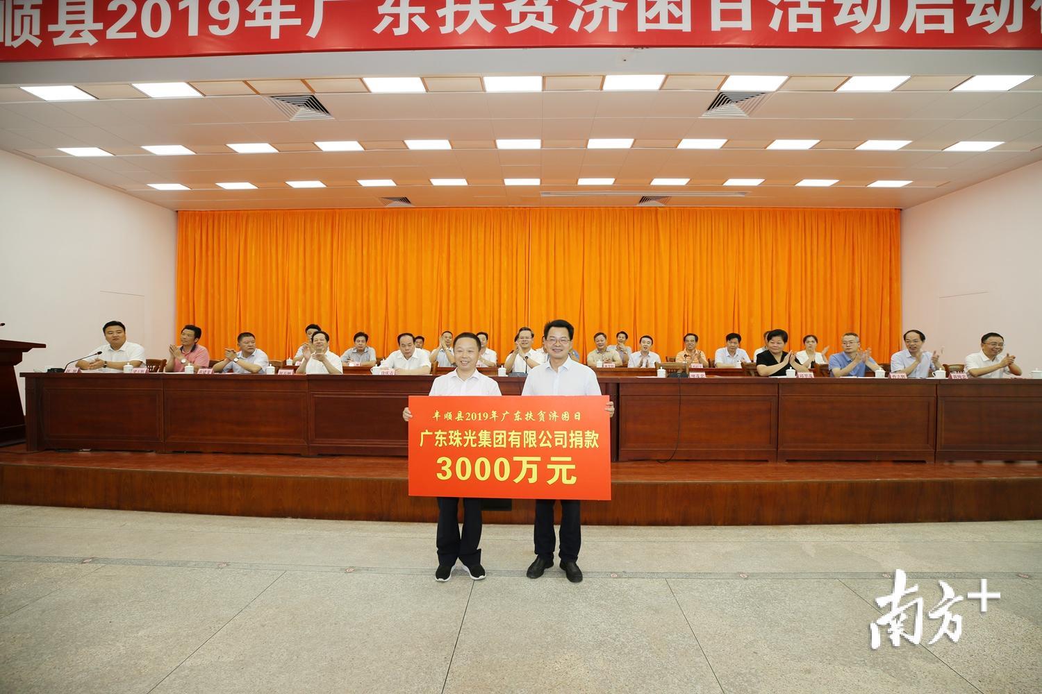 广东珠光集团有限公司举牌捐款3000万元，县长廖茂忠代表县政府接受捐款。（胡金辉 摄）