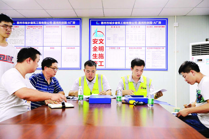 第三方评估单位工作人员在仲恺建筑工地检查建筑资料台账。