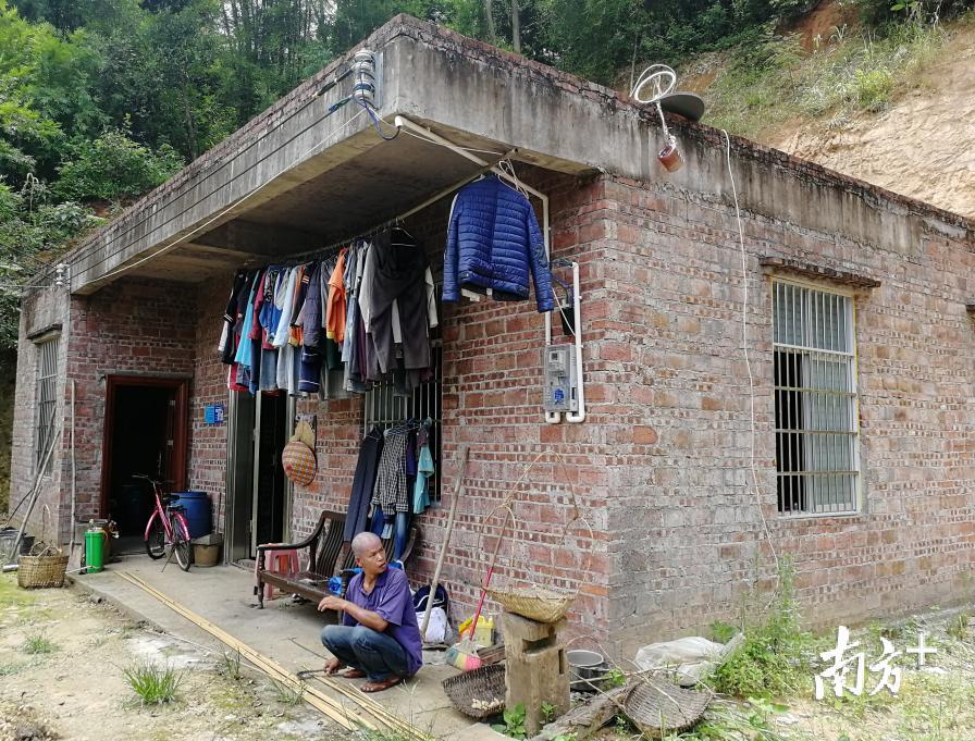 邱海平正在新家门前做手工。 邱海平正在新家门前做手工。