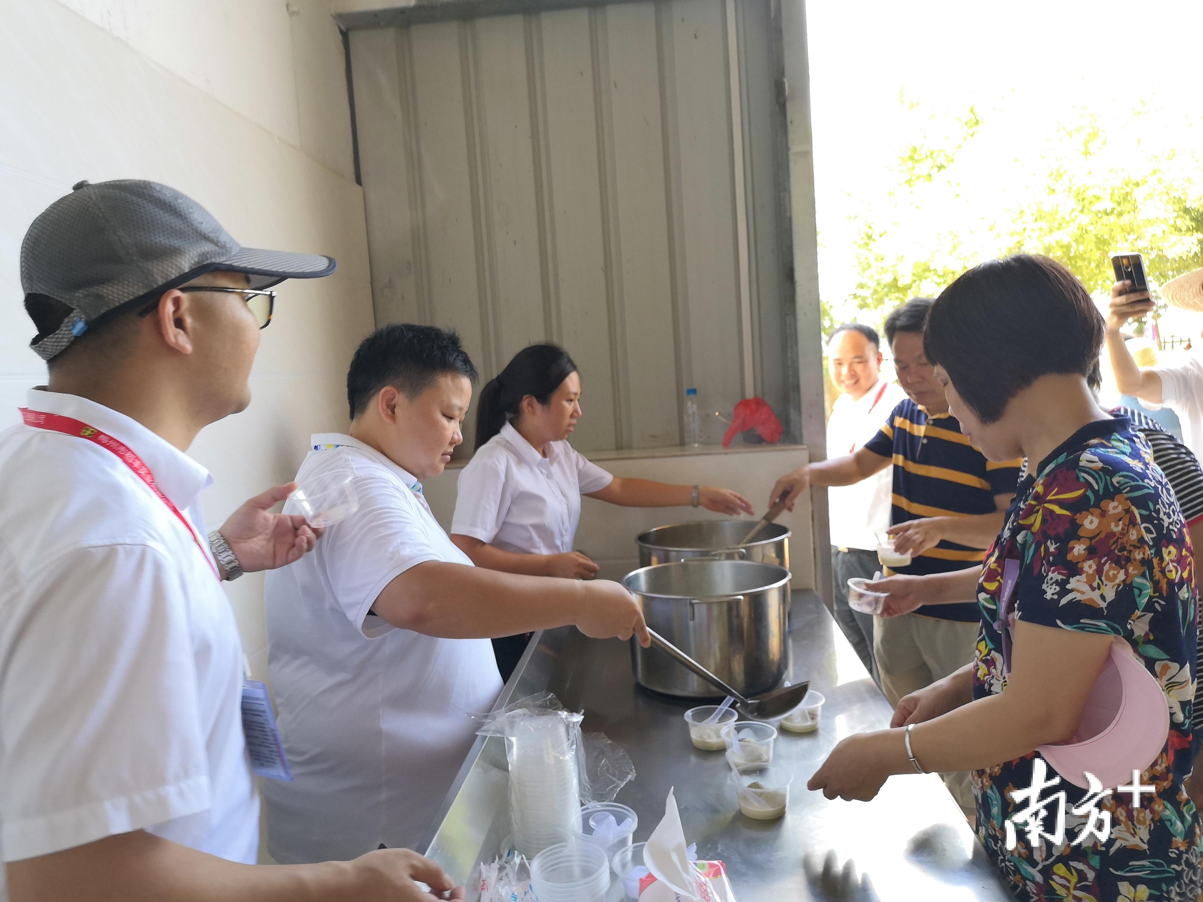 市民现场品尝稻米和鱼汤，并啧啧称赞。