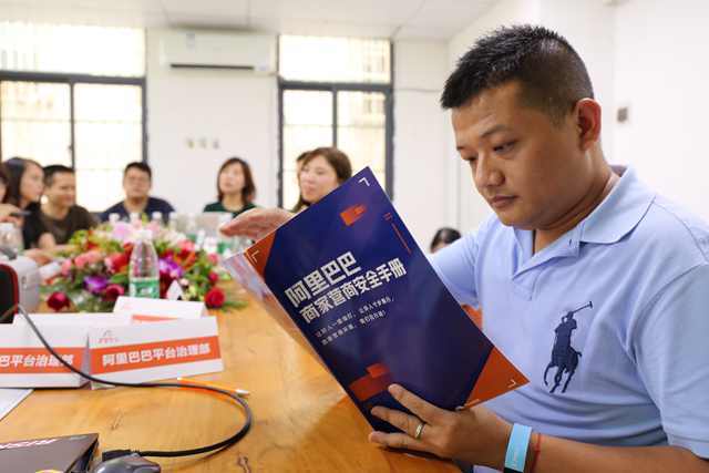 广州大源村淘宝商家翻看营商安全手册，与阿里小二现场交流。