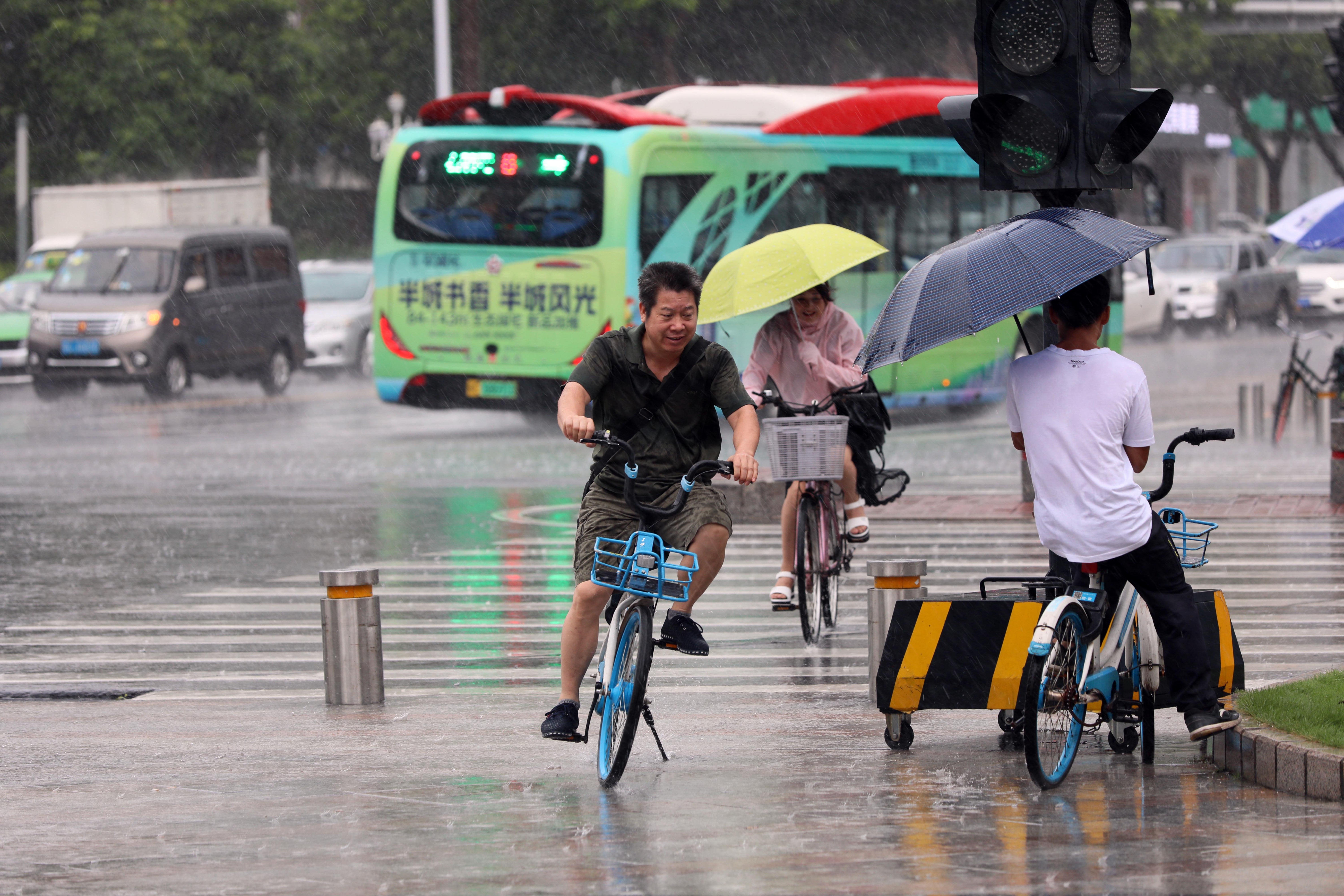 男子在雨中骑着单车快速前行