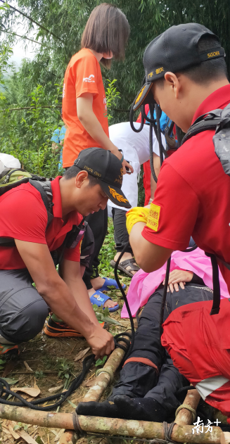 赵健华(左一)与救援队制作担架将受伤驴友抬出。 赵健华(左一)与救援队制作担架将受伤驴友抬出。
