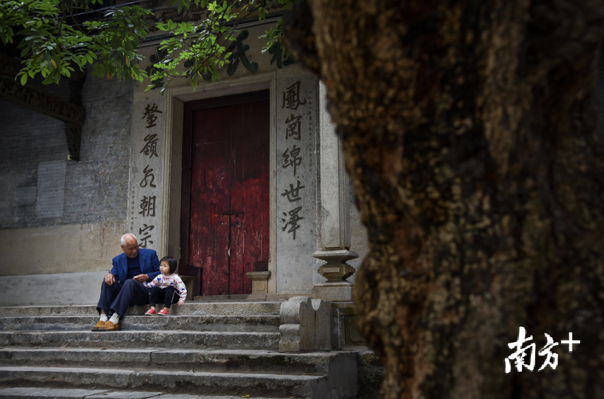 三水祠堂文化浓厚,一位村民在祠堂门前弄孙为乐。 三水祠堂文化浓厚,一位村民在祠堂门前弄孙为乐。