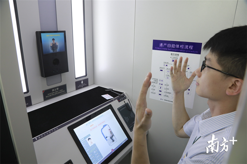 一名市民正在一台写着“车管所一站式便民服务”的设备上办理新的驾驶证。