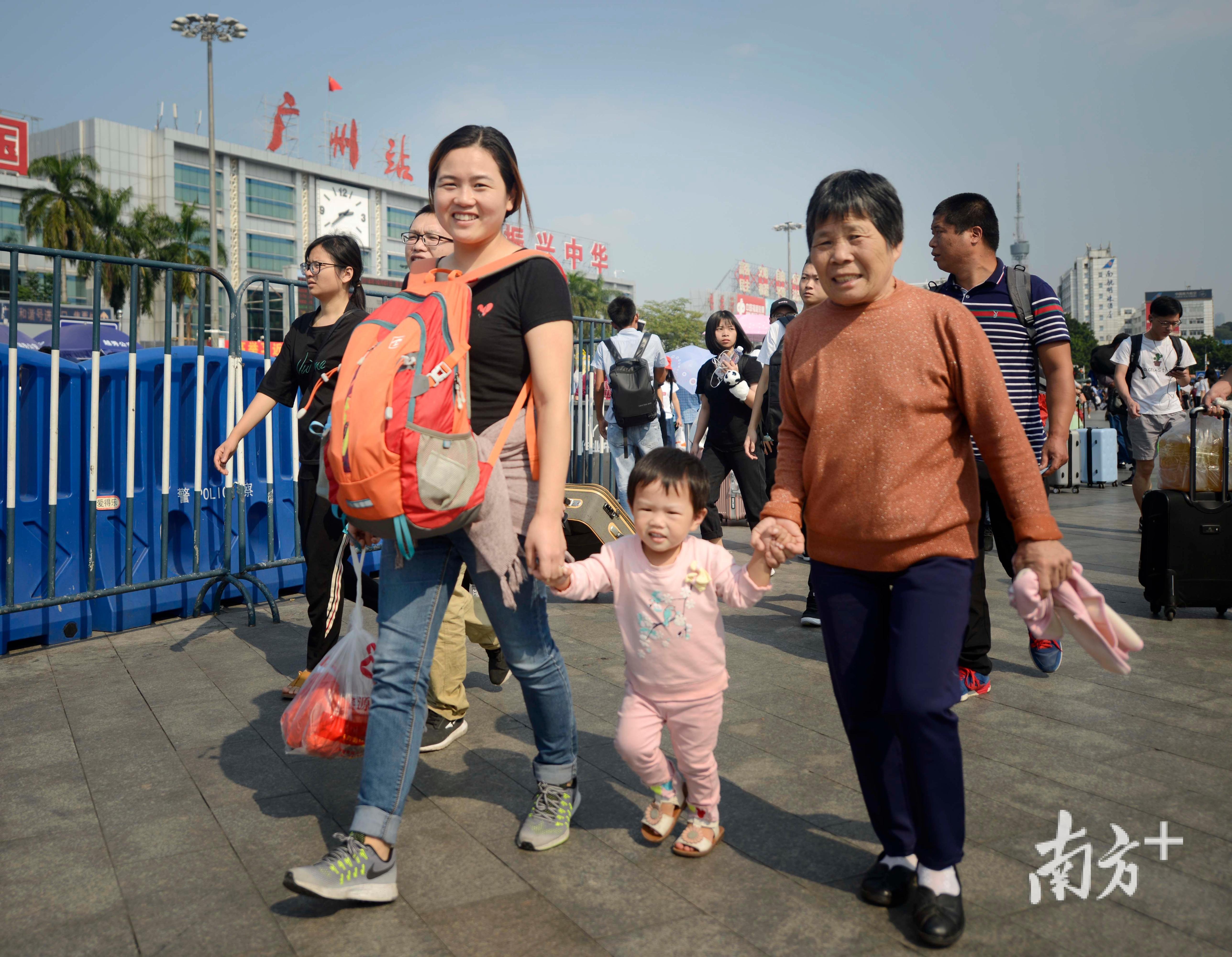 旅客洋溢着笑容走出广州火车站出站口。南方日报记者 肖雄 摄