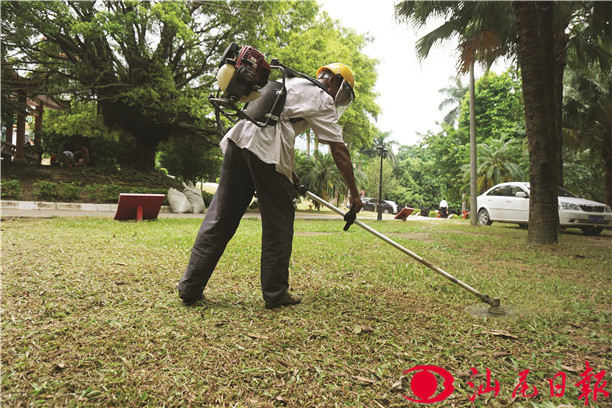 工人采用除草机清除公园杂草。 工人采用除草机清除公园杂草。