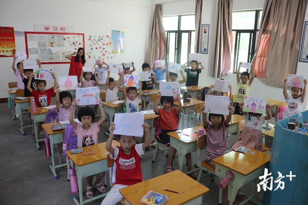 孩子们兴高采烈地展示美术作品。