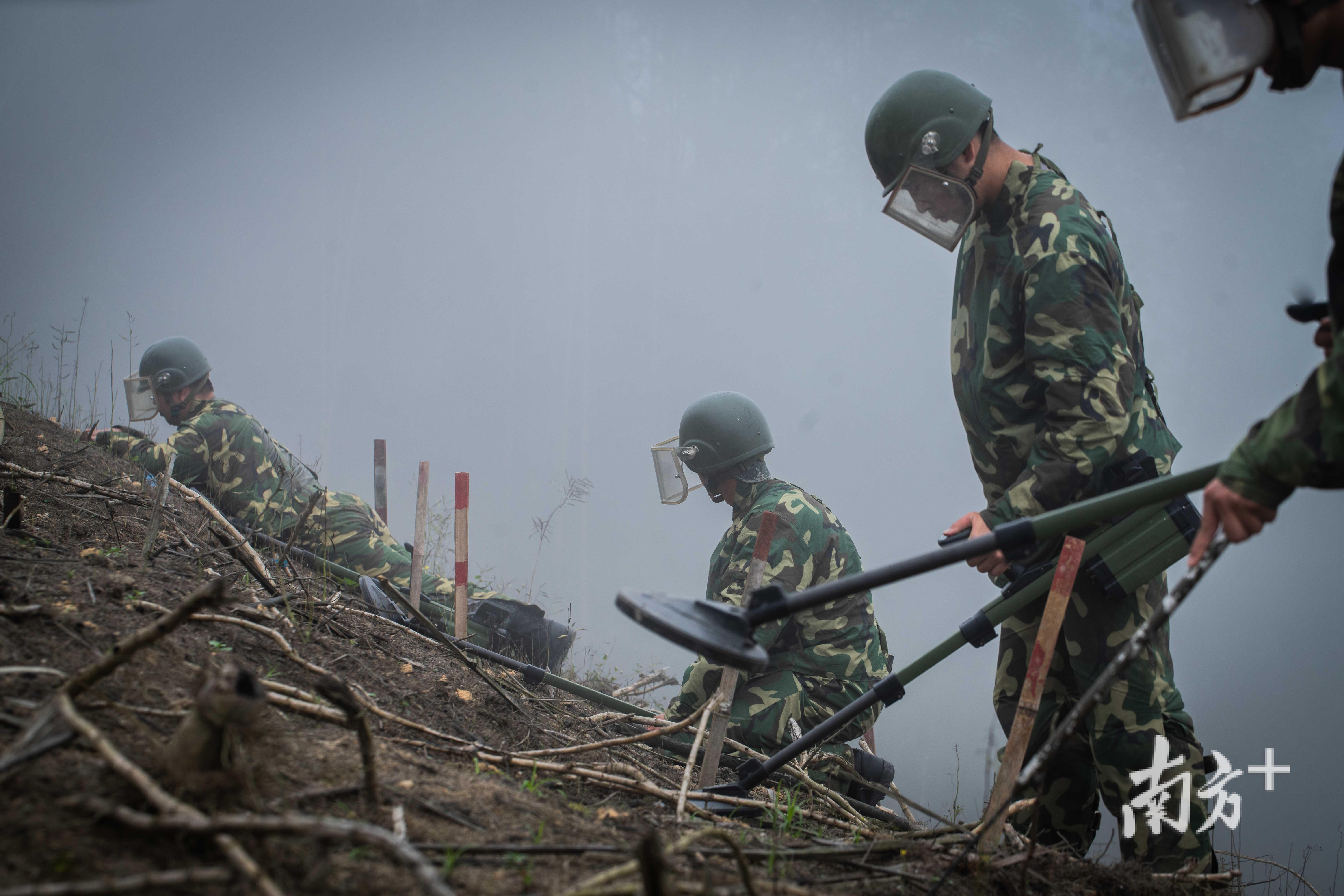 掃雷戰士們往往兩人一組,他們手持探雷器搜索地雷.