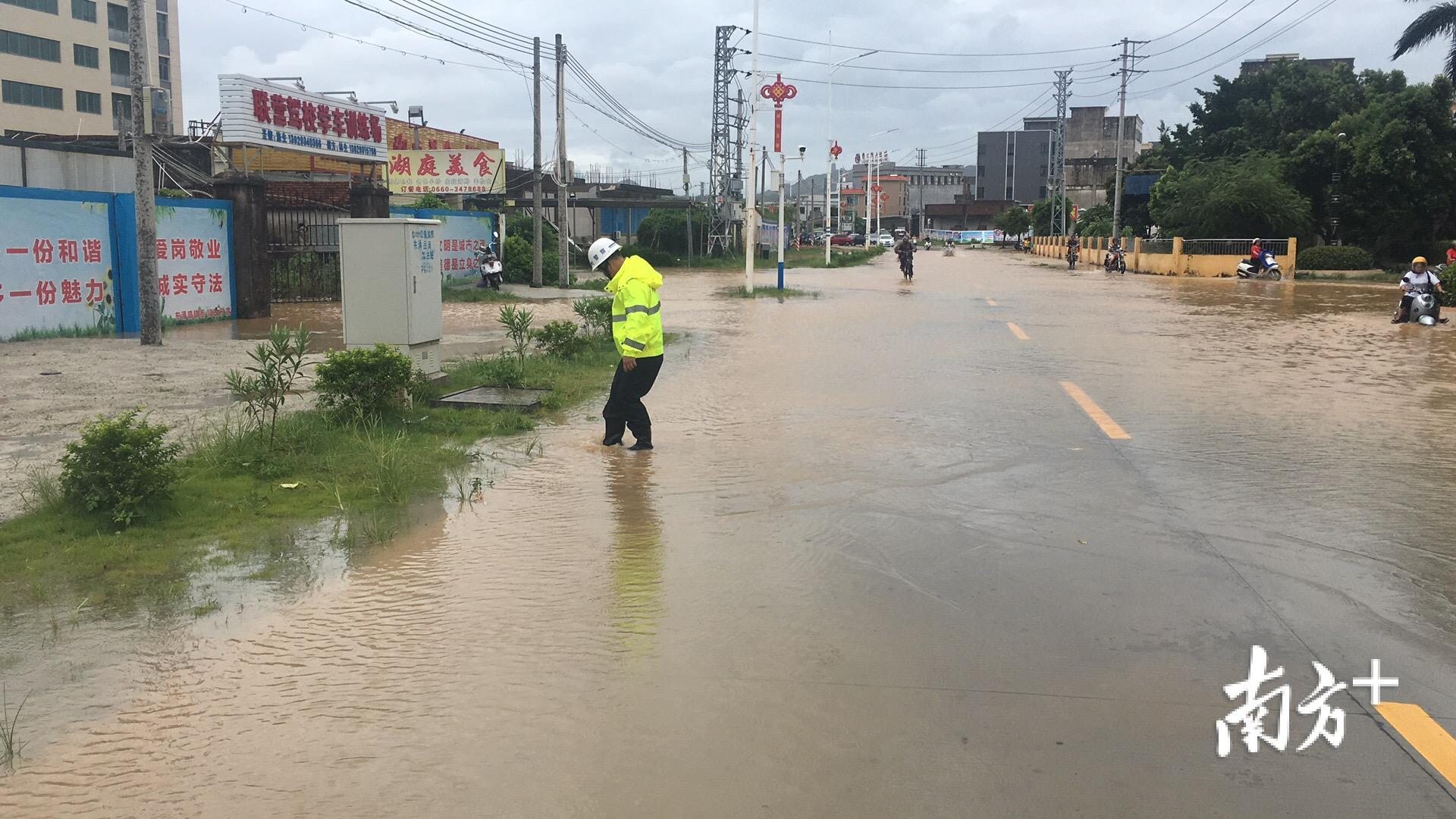 交警疏通下水道，排除积水。