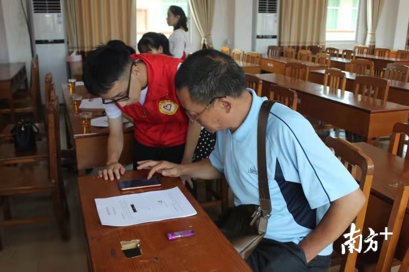 来自中山大学的廖文毓在基层一线讲解志愿者注册方法。