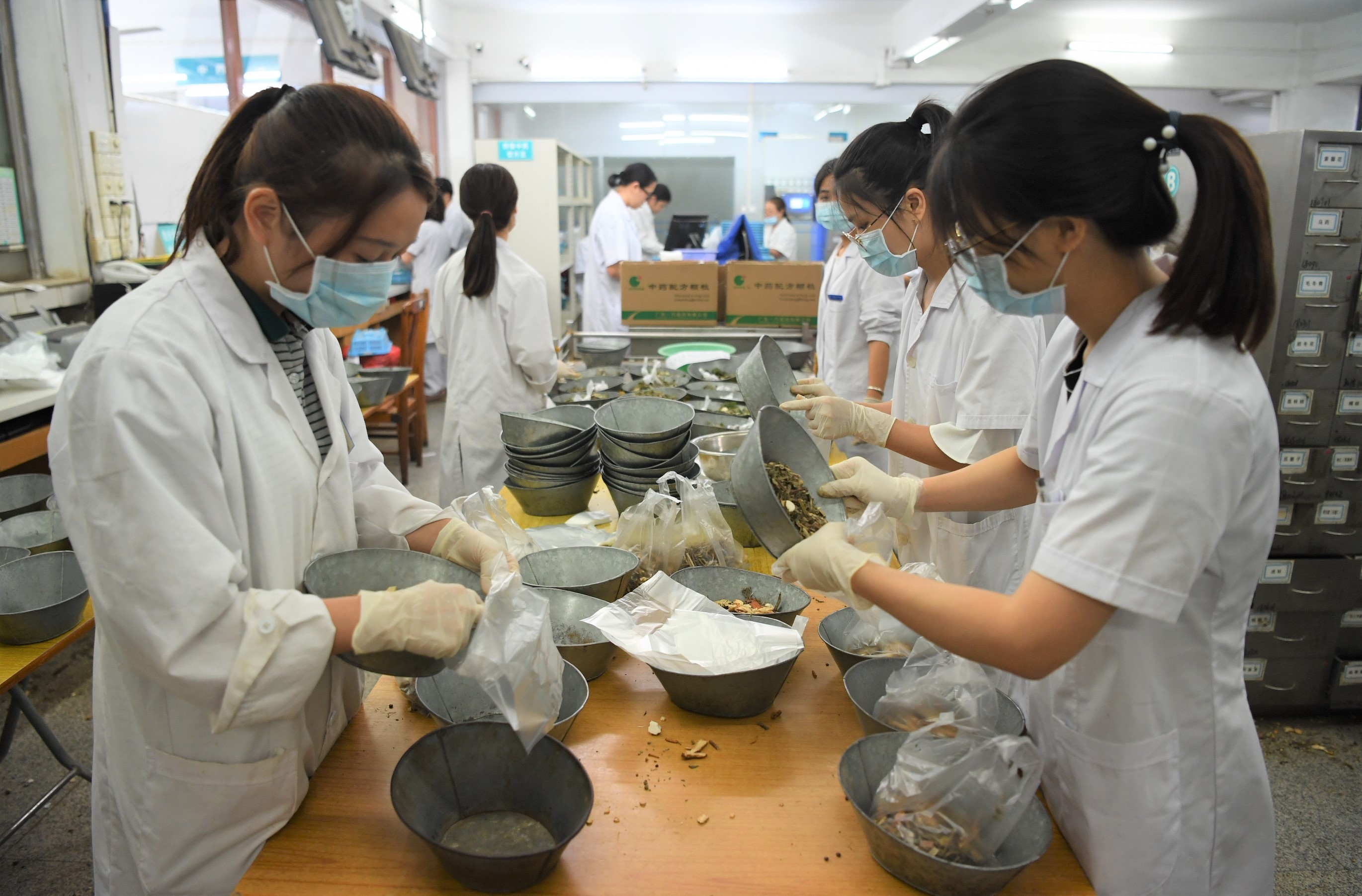 在江门市五邑中医院中药房内，药剂师在为患者调配中药。杨兴乐 摄