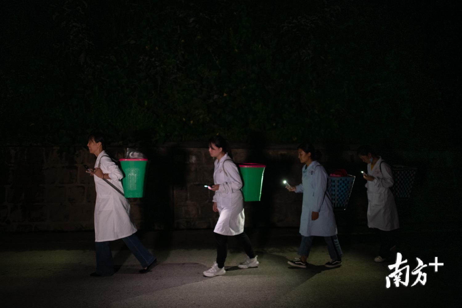 管延萍与其他医生打着手电筒到村里为村民们夜诊。