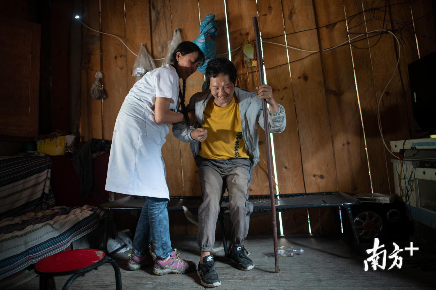 管延萍扶着何宝文，鼓励其独立行走，加强锻炼。