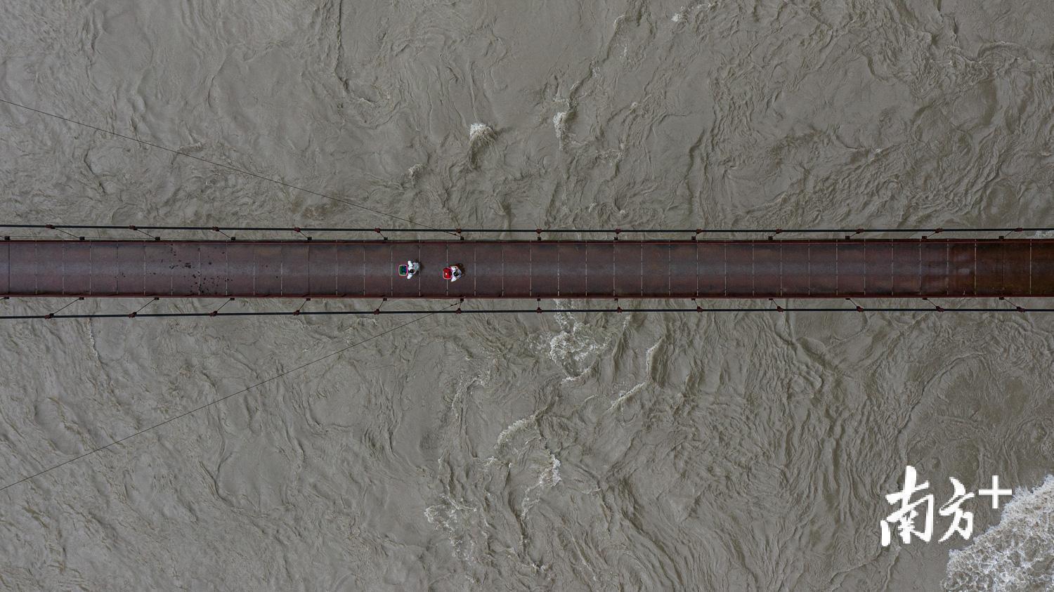 管延萍（右一）和护士林湘走在吊桥上，前往村里为村民们看病。