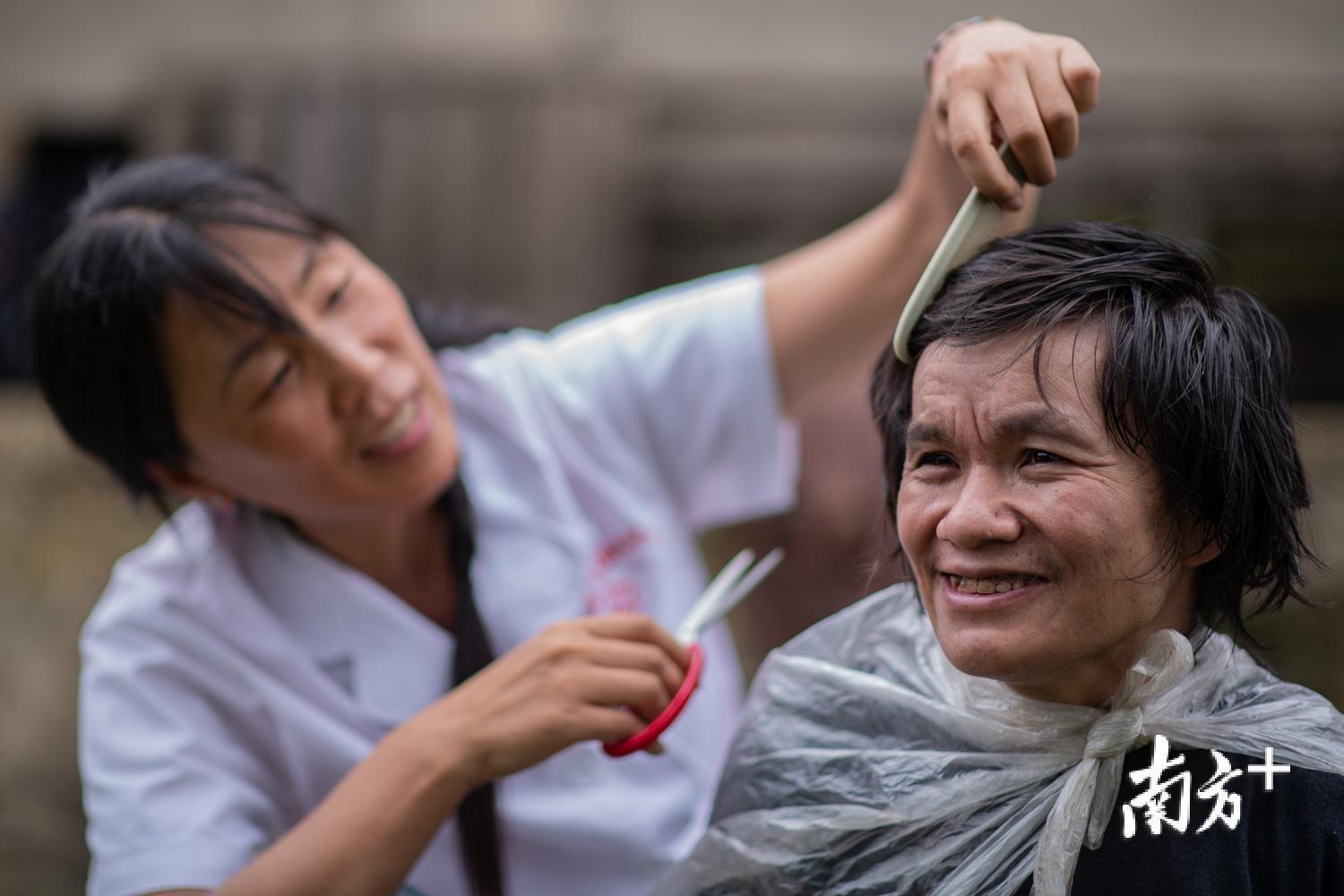 管延萍为学罗军剪头发。