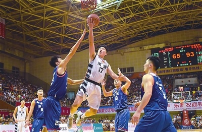 东莞队队员试图封盖河源队队员上篮。