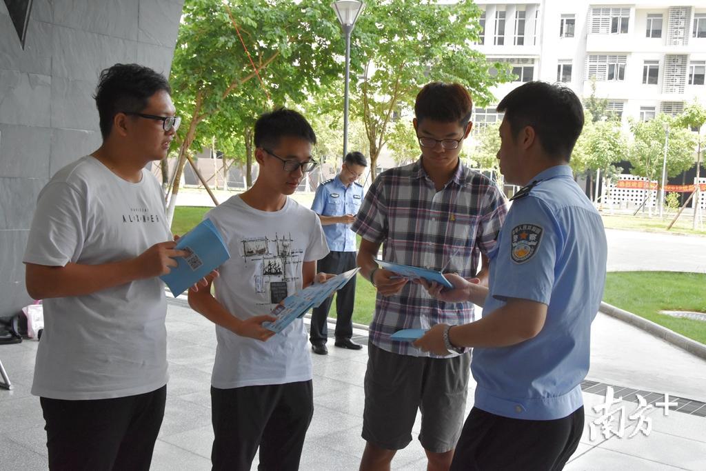 民警将宣传手册送到同学们手中。