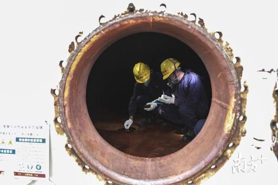 东莞立沙岛的化学品储存罐内，特检员在罐内检查储存罐是否存在风险。