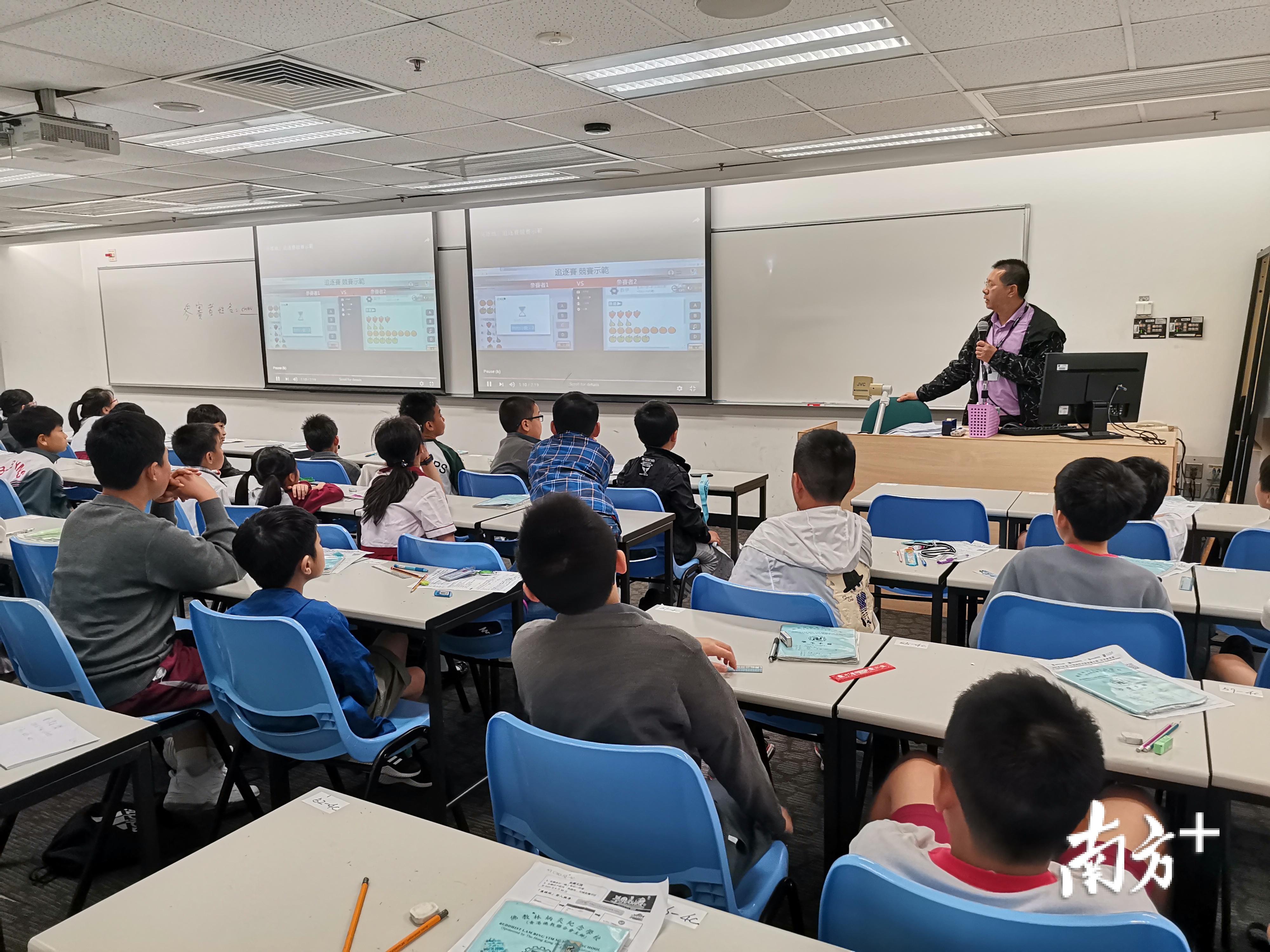 曹锡光向学生介绍第16届国际资优解难比赛。 受访者 供图 曹锡光向学生介绍第16届国际资优解难比赛。 受访者 供图