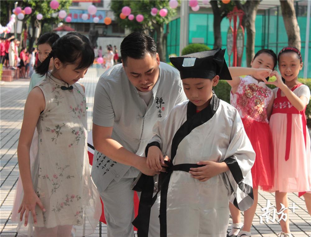 老师细心为小朋友整理服装。