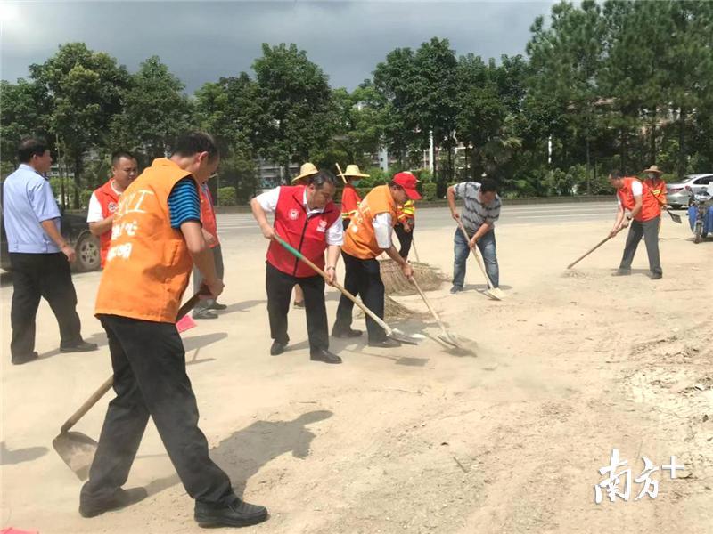 李惠文在“清障洁城，美化家园”行动中。李霭莹 摄
