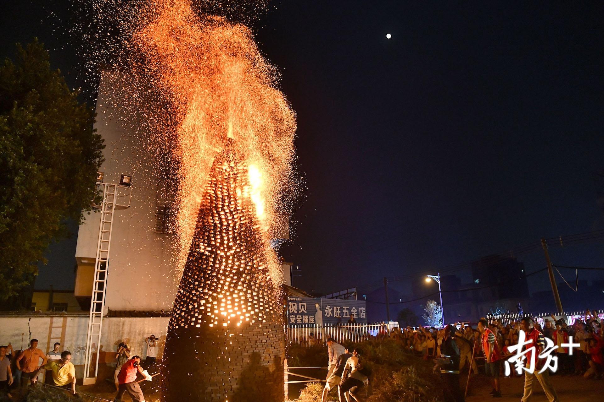 数位村民上前抡起铁锹将塱枝“捅”进番塔内，撩起那些还未完全燃烧的塱枝，番塔顶端的火苗便立即蹿升至十几二十米。戴嘉信 摄
