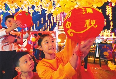 9月13日，在磁县方特主题公园内，小朋友将制作好的中秋灯笼挂到许愿树上。新华社发