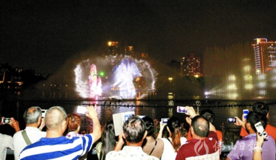 市民拿出手机拍摄文华公园水舞声光秀。 佛山日报记者张弘弢摄