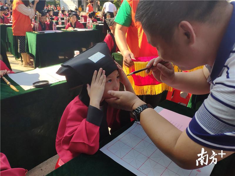 嘉宾们用红色的朱砂在学子们的额头正中点上红痣。黄绍侦 摄