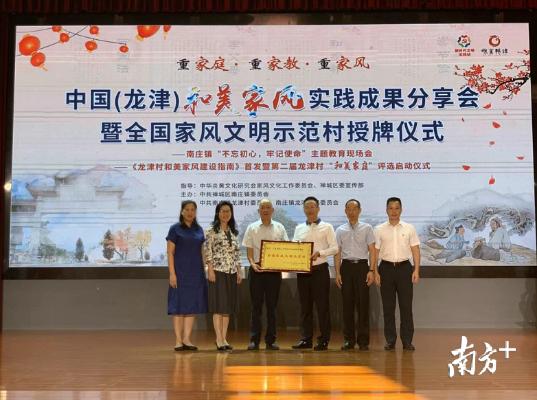 中华炎黄文化研究会家风文化工作委员会会长林亚明向龙津村党委书记、村委会主任冯耀泉颁发“全国家风文明示范村”牌匾。李晓玲 摄